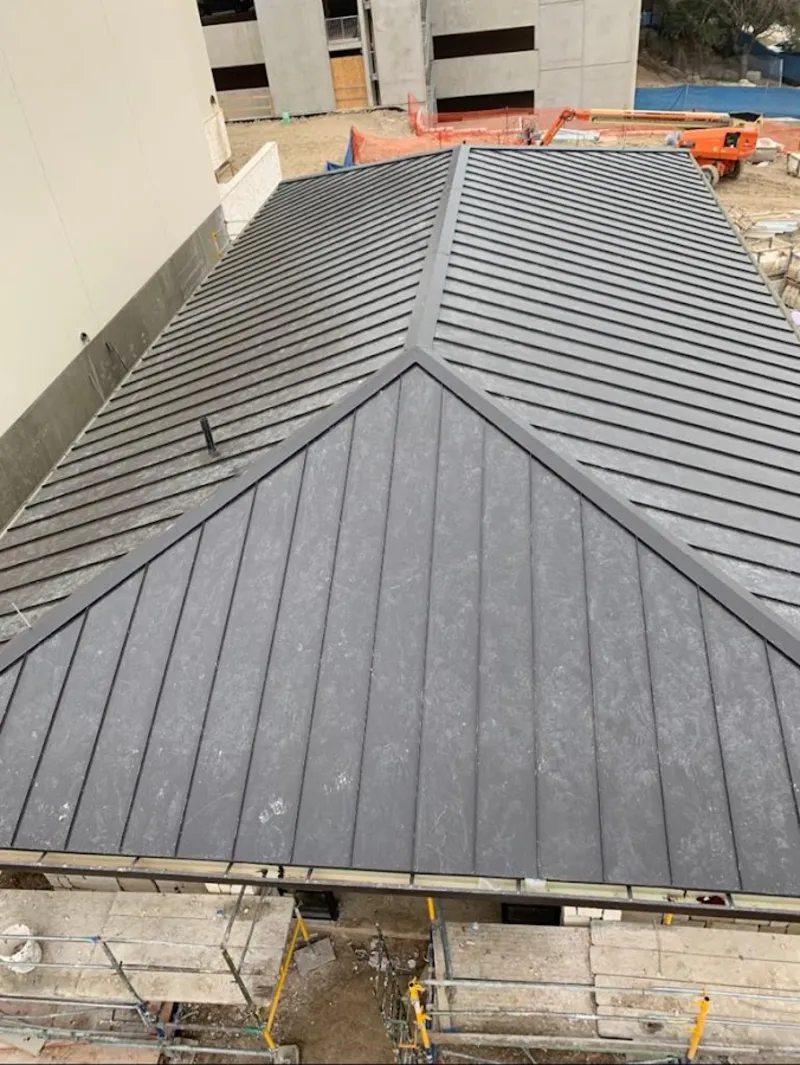 Commercial metal roof construction with crane equipment in River Park